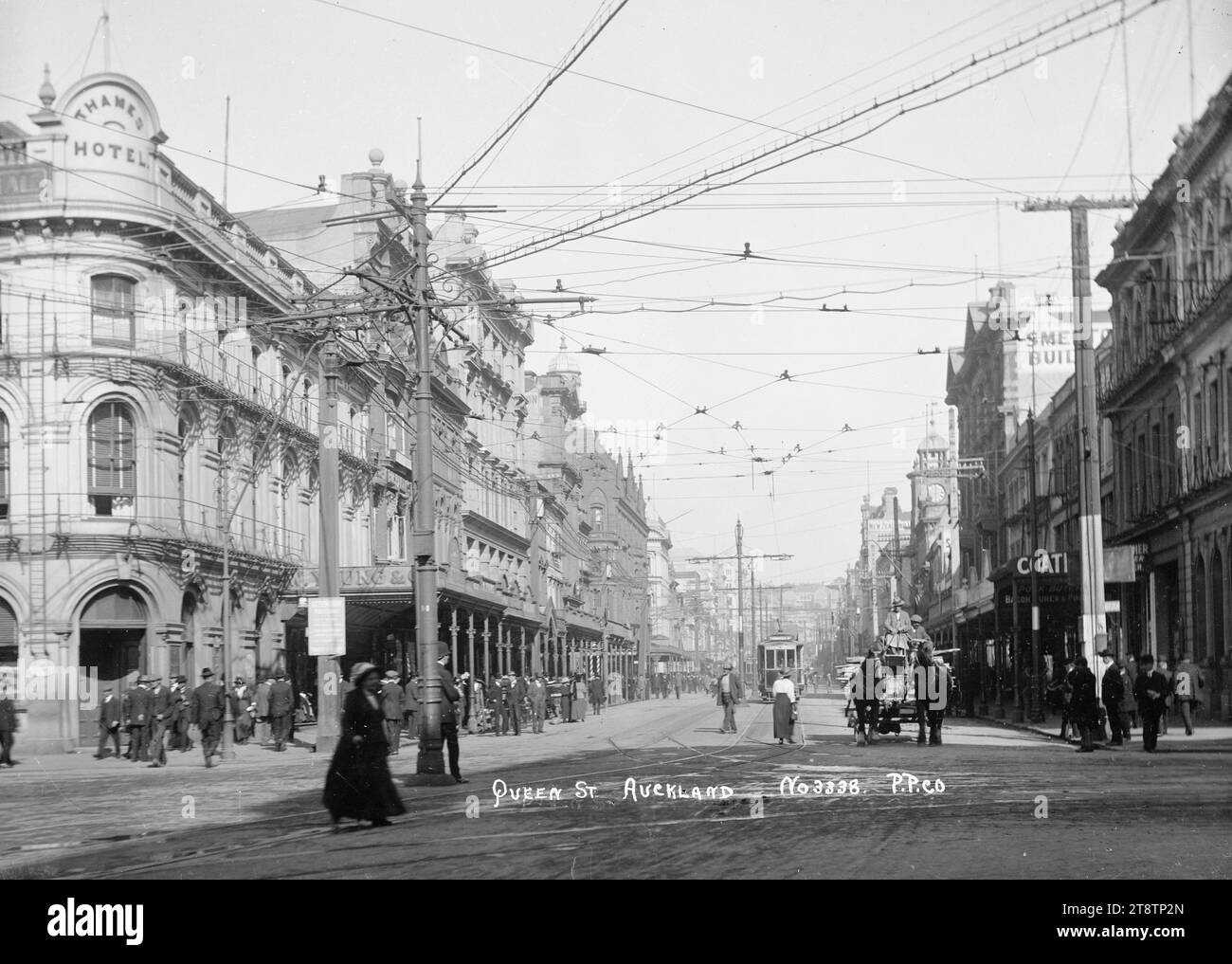 View looking up Queen Street from the Custom Street intersection, Auckland, New Zealand, View taken from the Customs Street intersection looking up Queen Street. On the lefthand side is the Thames Hotel with W Young & Co next door. In the foreground is a horse-drawn cart with a load of timber. A tram car with `Dominion Road' on the front can be seen in the middle distance, ca 1915-1920 Stock Photo